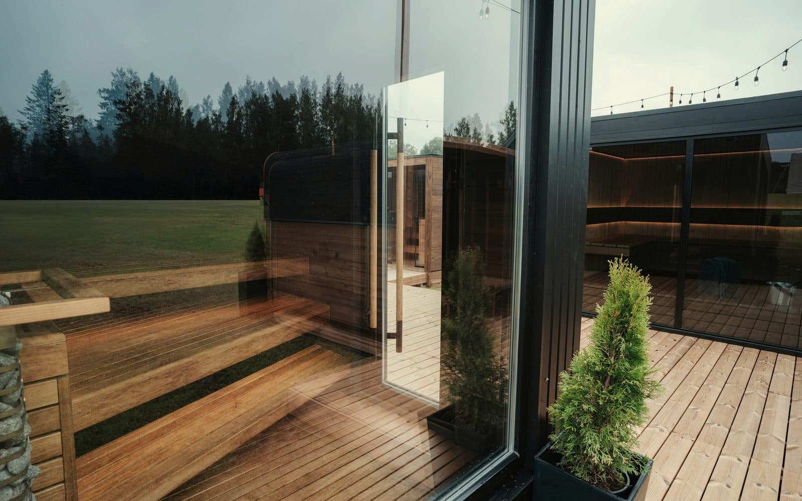 Glass-fronted outdoor sauna cabin on a timber deck